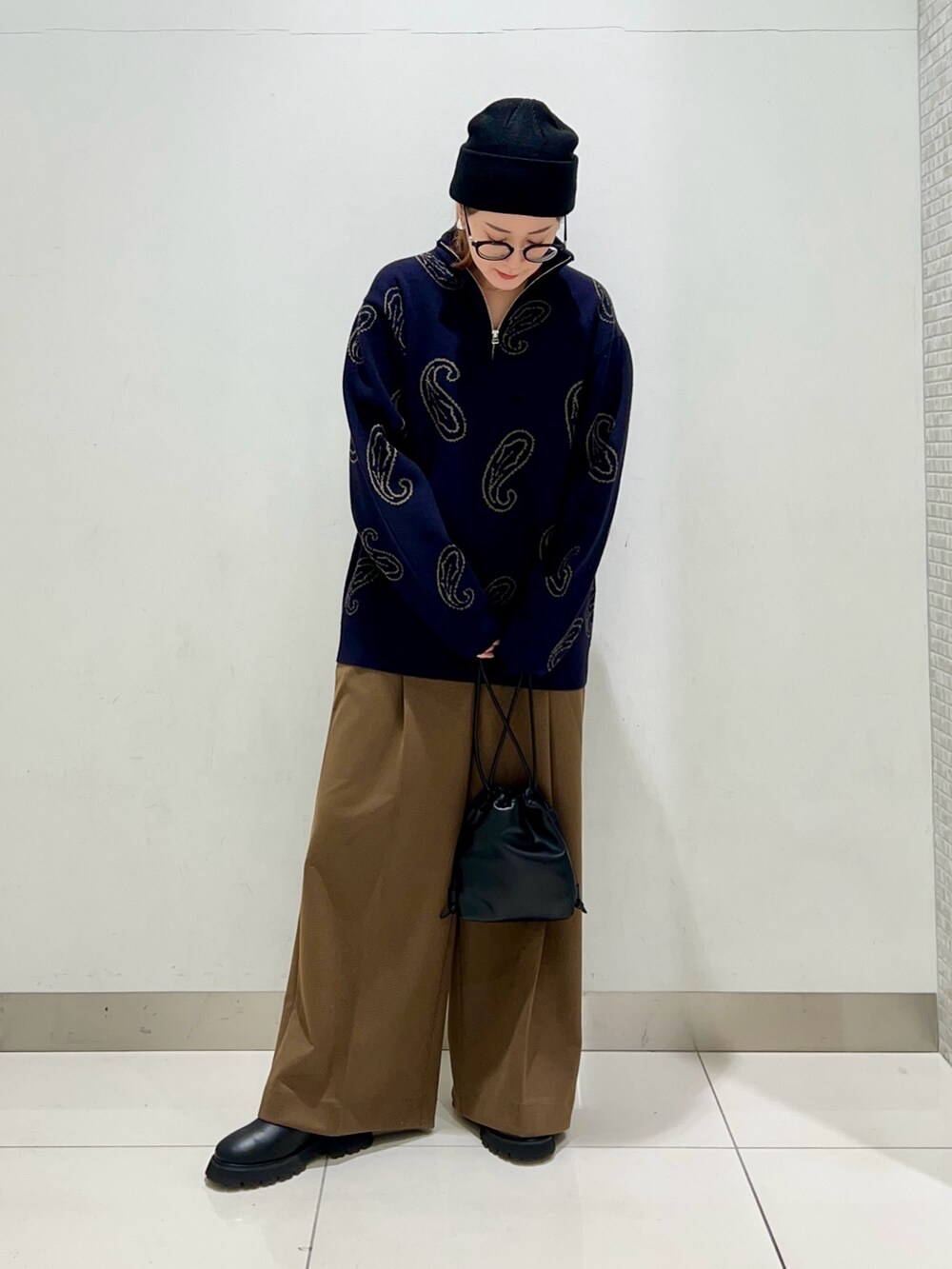 ブルー系のニット/セーター、ブラック系のショルダーバッグ、ベージュ系のその他パンツを着用したレディースの冬コーディネートの2枚目の写真