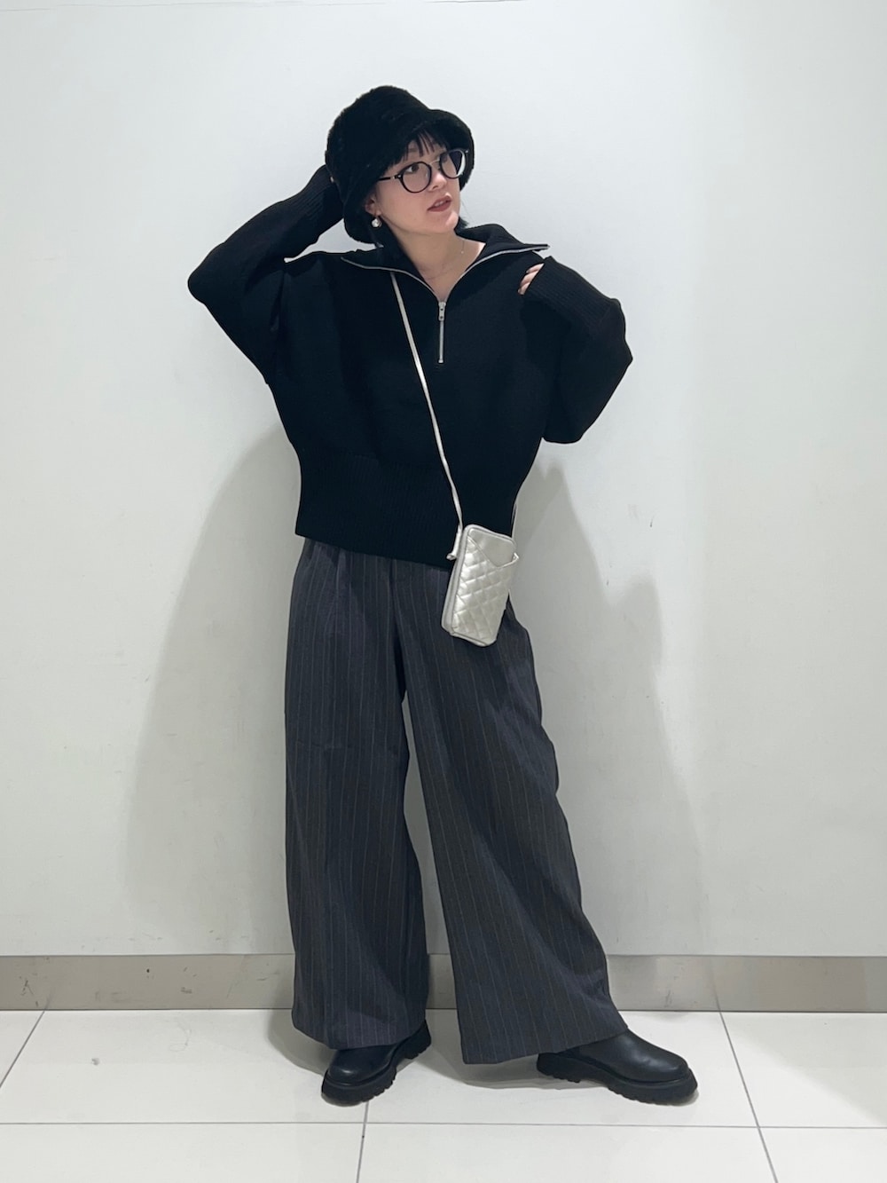 グレー系のその他パンツ、ブラック系のニット/セーター、シルバー系のショルダーバッグを着用したレディースの秋コーディネートの2枚目の写真