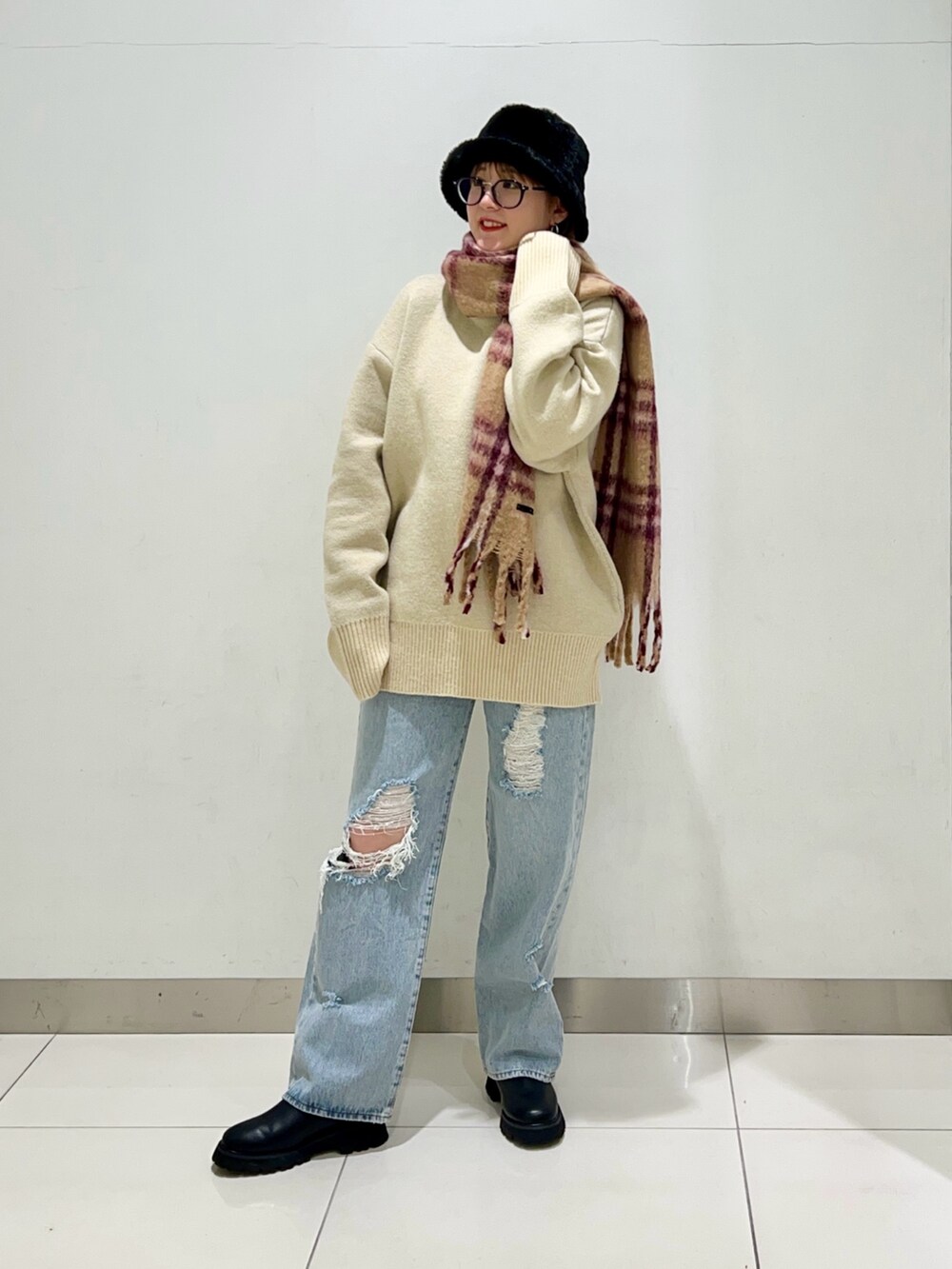 ブラック系のショルダーバッグ、ブルー系のデニムパンツ、ブラック系のブーツを着用したレディースの冬コーディネートの7枚目の写真