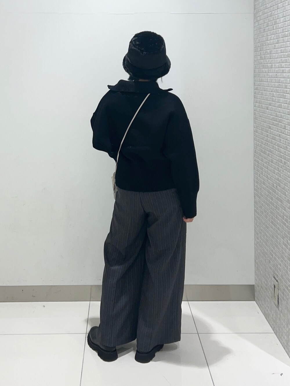 グレー系のその他パンツ、ブラック系のニット/セーター、シルバー系のショルダーバッグを着用したレディースの秋コーディネートの4枚目の写真