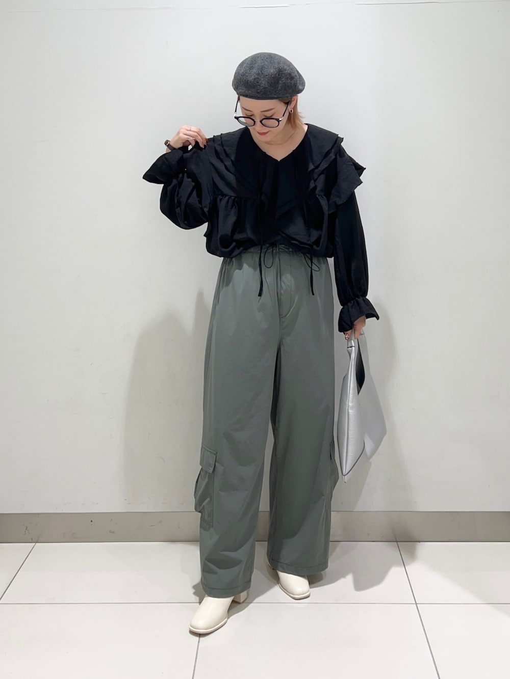 ブラック系のシャツ/ブラウス、グリーン系のサロペット/オーバーオール、ホワイト系のブーツを着用したレディースの秋コーディネートの6枚目の写真