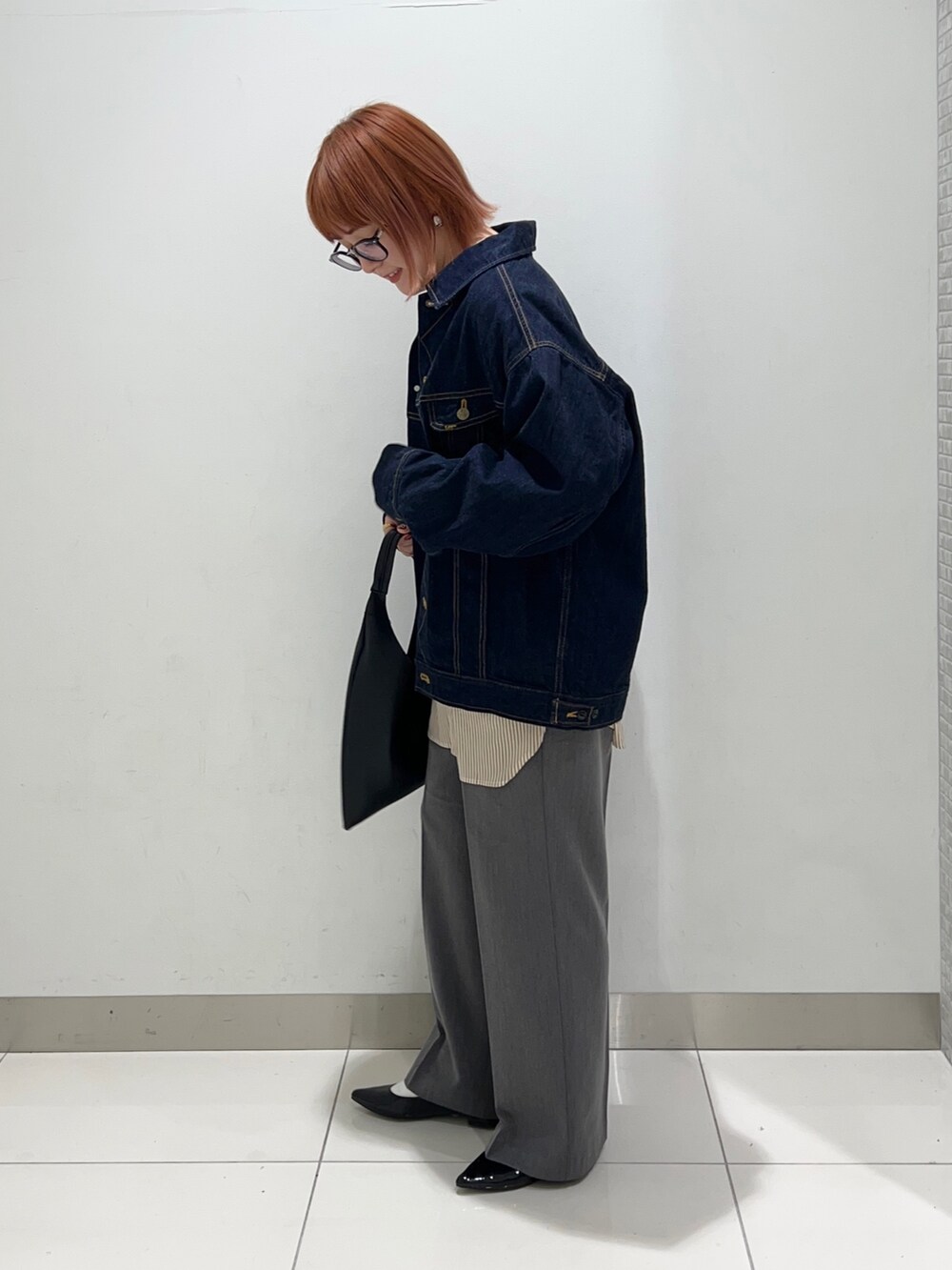 イエロー系のシャツ/ブラウス、ブルー系のデニムジャケット、グレー系のスラックスを着用したレディースの秋コーディネートの3枚目の写真