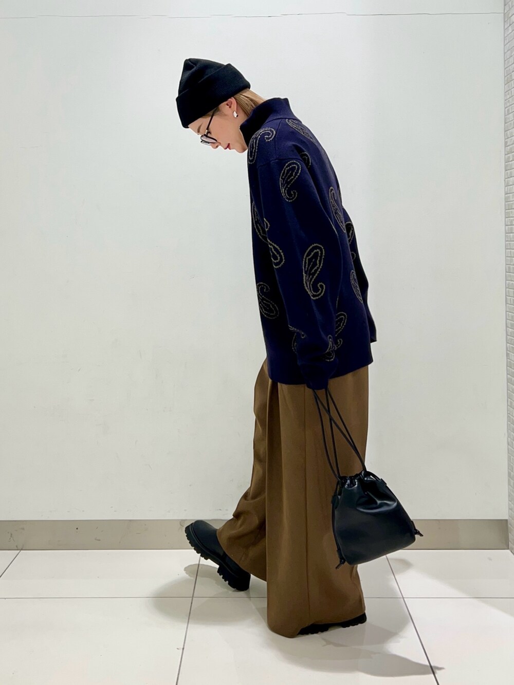 ブルー系のニット/セーター、ブラック系のショルダーバッグ、ベージュ系のその他パンツを着用したレディースの冬コーディネートの3枚目の写真