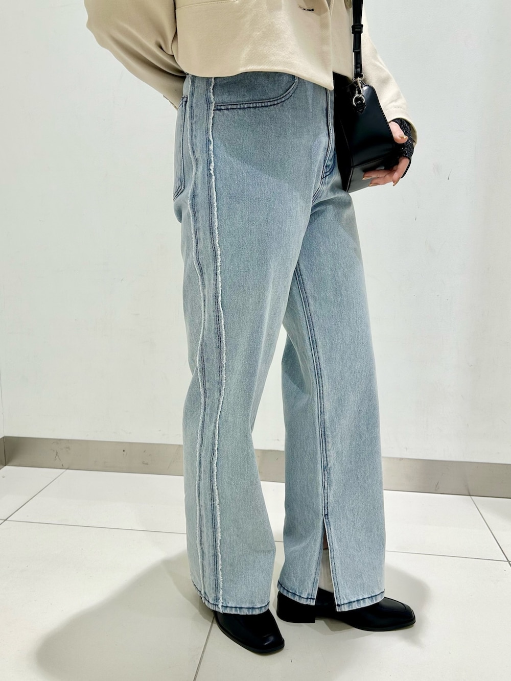 ブラック系のTシャツ/カットソー、ベージュ系のその他アウター、ブラック系のショルダーバッグを着用したレディースの春コーディネートの7枚目の写真