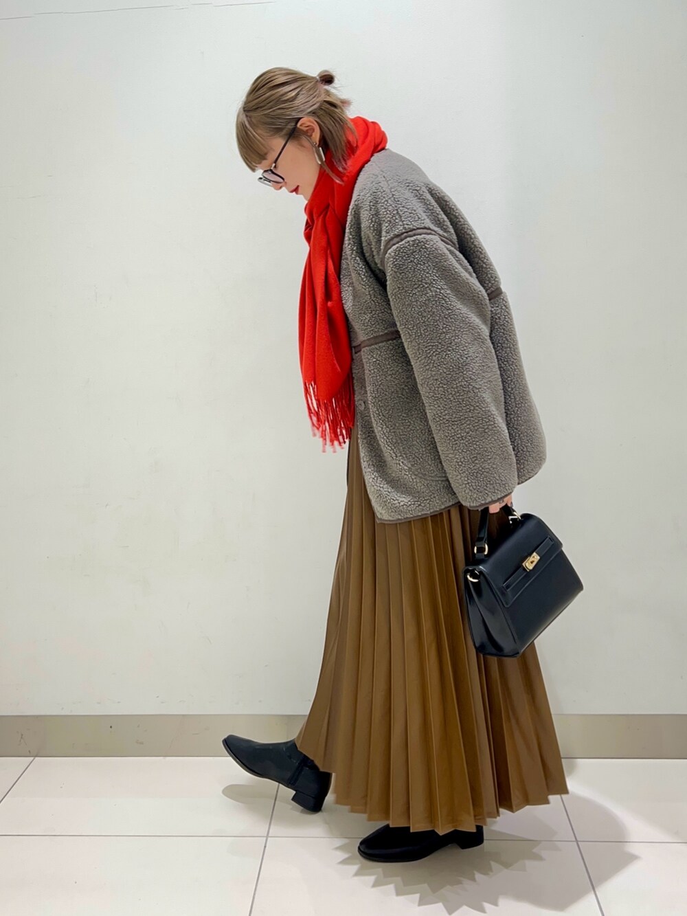 ブラック系のブーツ、ブラウン系のスカート、グレー系のその他アウターを着用したレディースの秋コーディネートの3枚目の写真