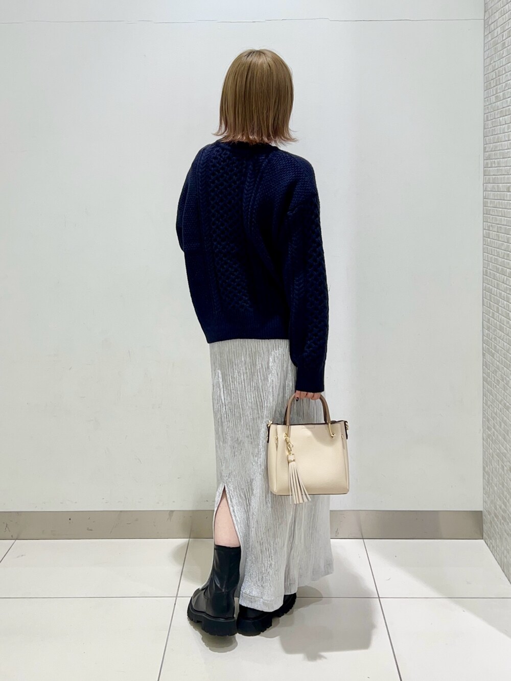 ブラック系のブーツ、グレー系のスカート、ブルー系のニット/セーターを着用したレディースの冬コーディネートの9枚目の写真