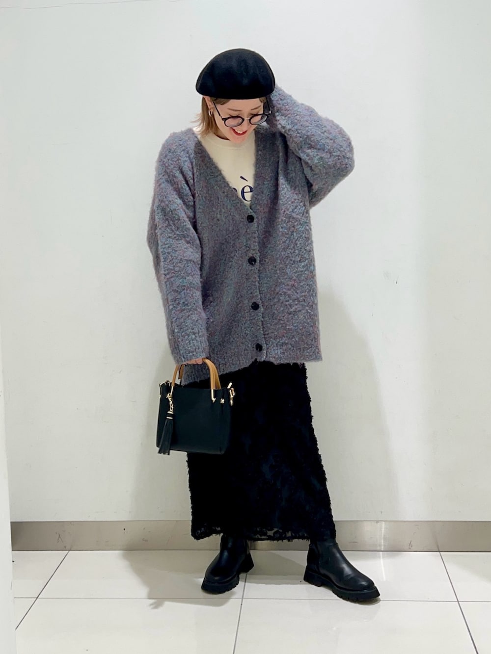 ホワイト系のニット/セーター、ブルー系のカーディガン/ボレロ、ブラック系のトートバッグを着用したレディースの冬コーディネートの2枚目の写真
