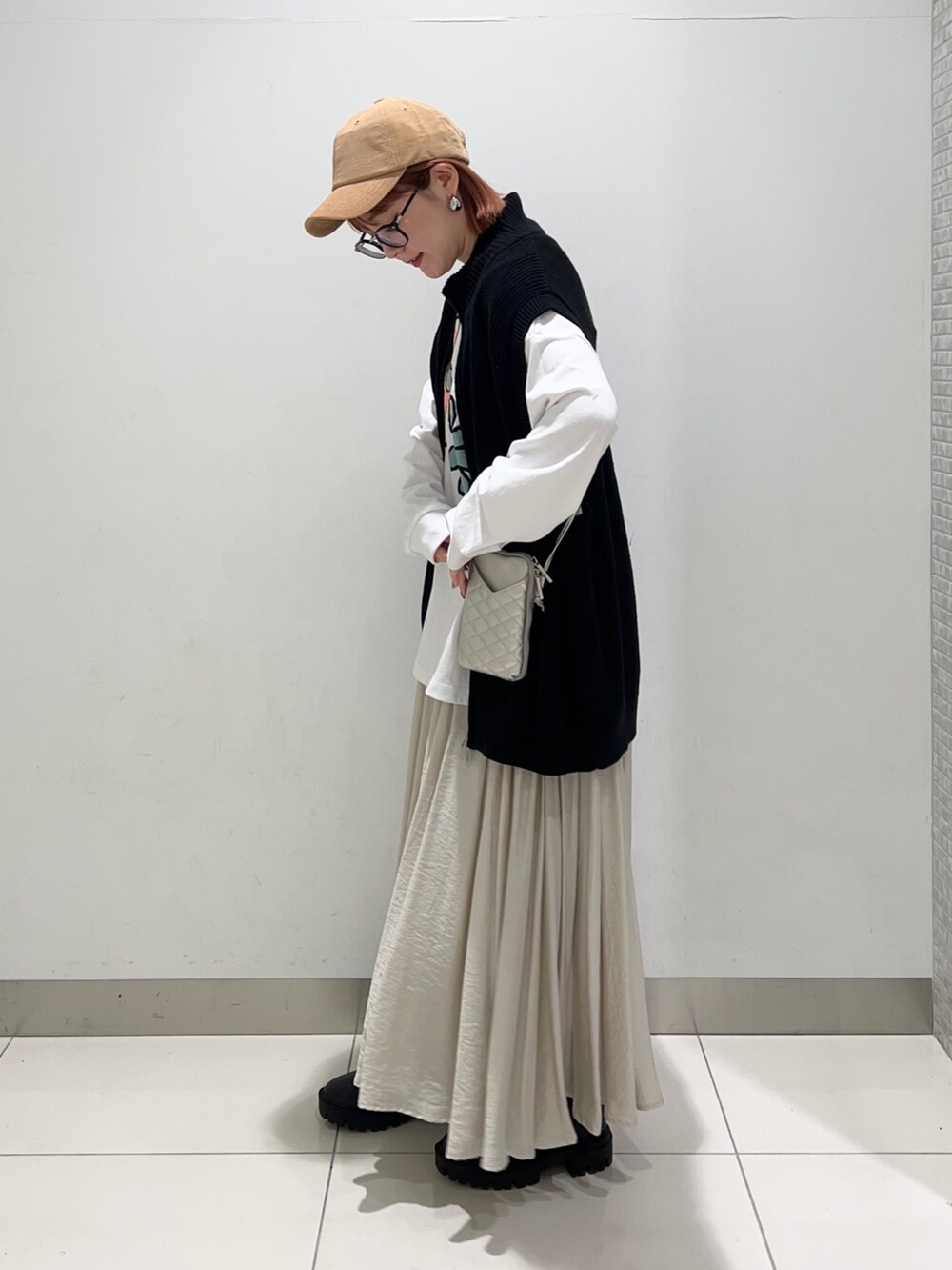 ホワイト系のTシャツ/カットソー、シルバー系のショルダーバッグ、ベージュ系のスカートを着用したレディースの秋コーディネートの3枚目の写真