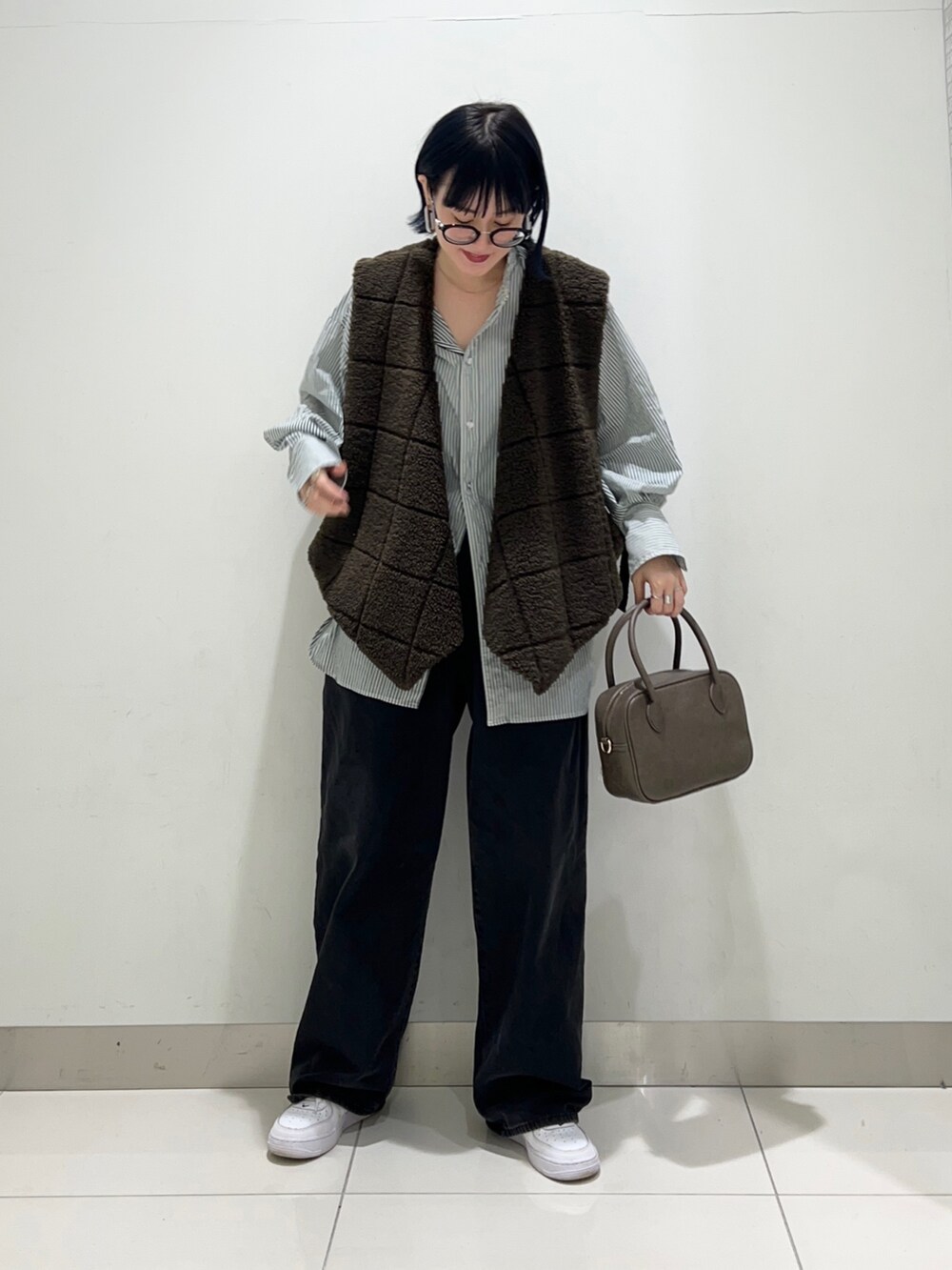 ブラック系のデニムパンツ、ブラウン系のボストンバッグ、グリーン系のシャツ/ブラウスを着用したレディースの秋コーディネートの6枚目の写真