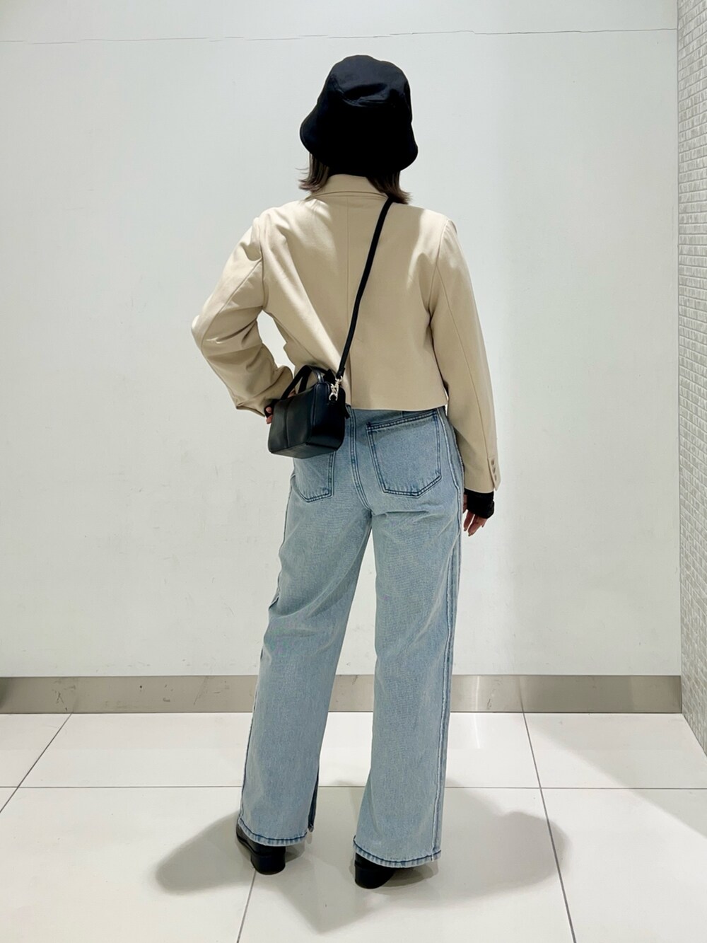 ブラック系のTシャツ/カットソー、ベージュ系のその他アウター、ブラック系のショルダーバッグを着用したレディースの春コーディネートの4枚目の写真