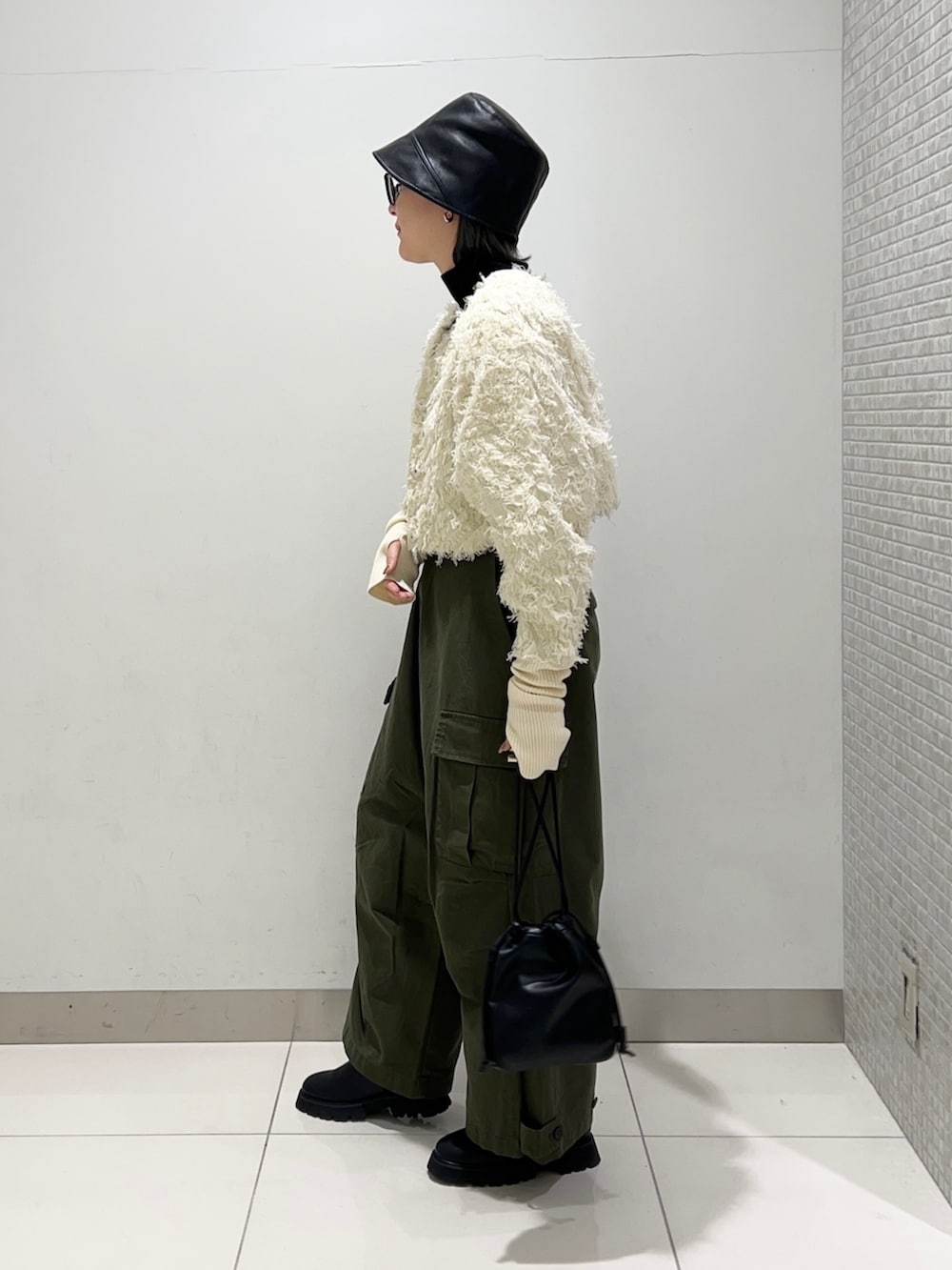 グリーン系のその他パンツ、ブラック系のショルダーバッグ、ブラック系のブーツを着用したレディースの秋コーディネートの3枚目の写真