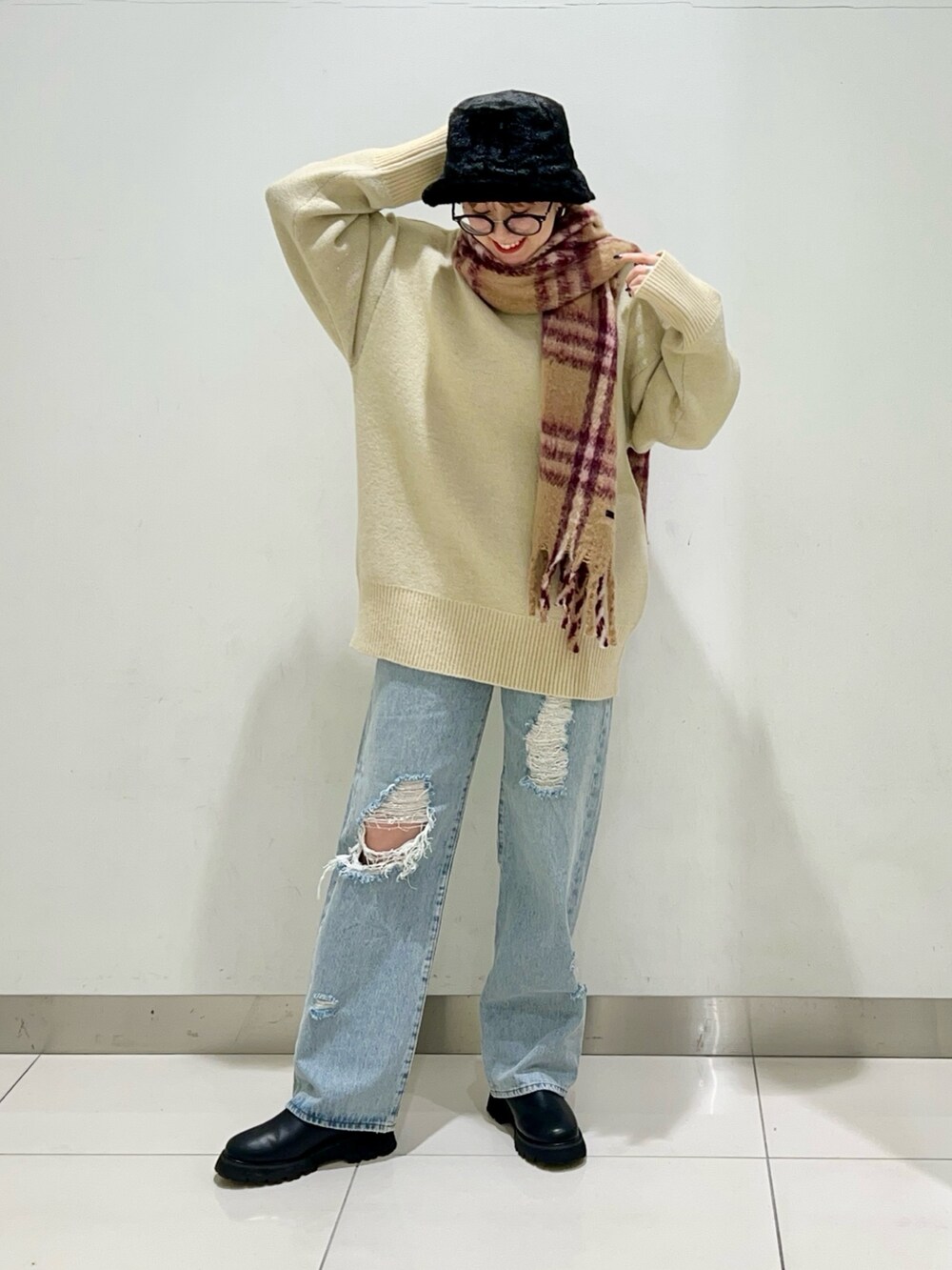 ブラック系のショルダーバッグ、ブルー系のデニムパンツ、ブラック系のブーツを着用したレディースの冬コーディネートの6枚目の写真