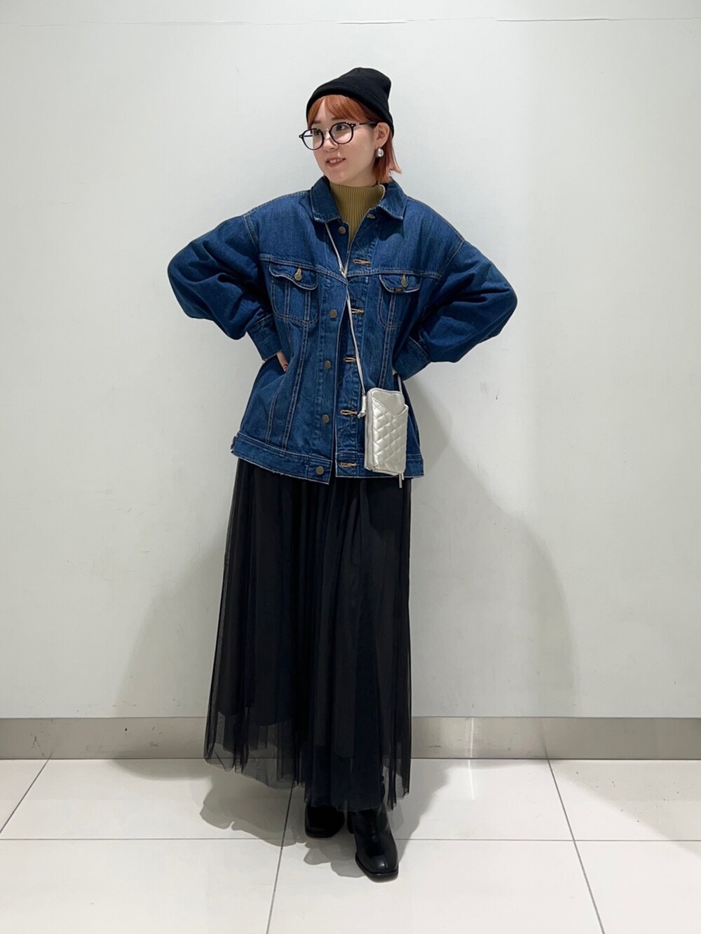 ブラック系のスカート、ブルー系のデニムジャケット、イエロー系のニット/セーターを着用したレディースの秋コーディネートの2枚目の写真