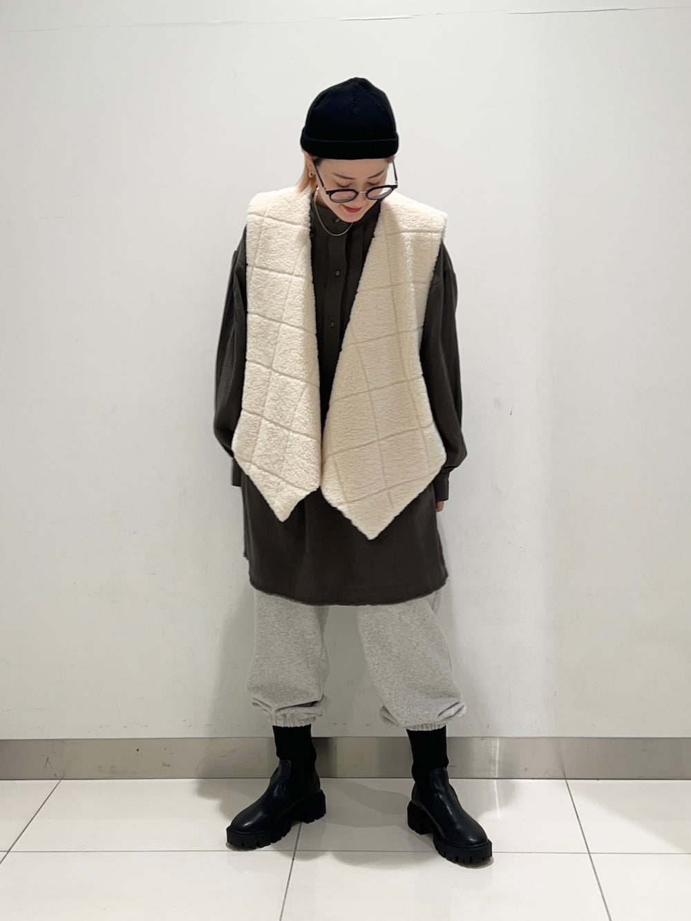 ホワイト系のベスト、グリーン系のワンピース、グレー系のその他パンツを着用したレディースの秋コーディネートの6枚目の写真