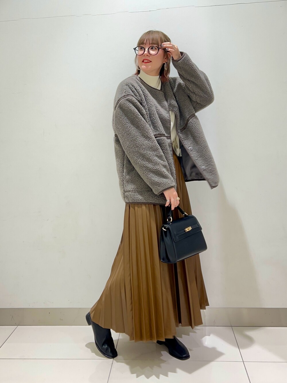 ブラック系のブーツ、ブラウン系のスカート、グレー系のその他アウターを着用したレディースの秋コーディネートの6枚目の写真