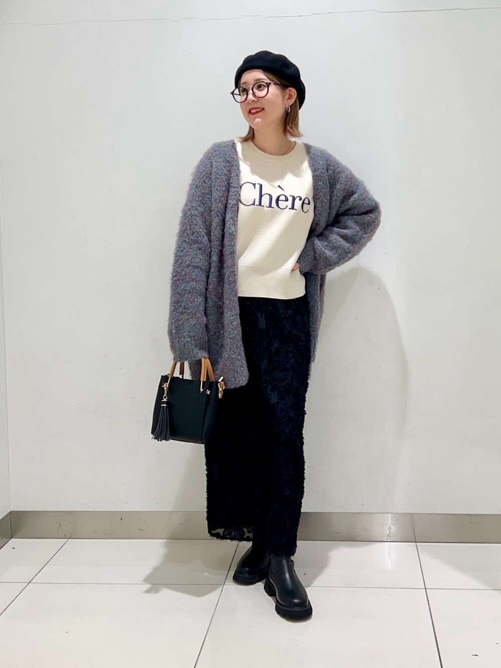 ホワイト系のニット/セーター、ブルー系のカーディガン/ボレロ、ブラック系のトートバッグを着用したレディースの冬コーディネートの7枚目の写真