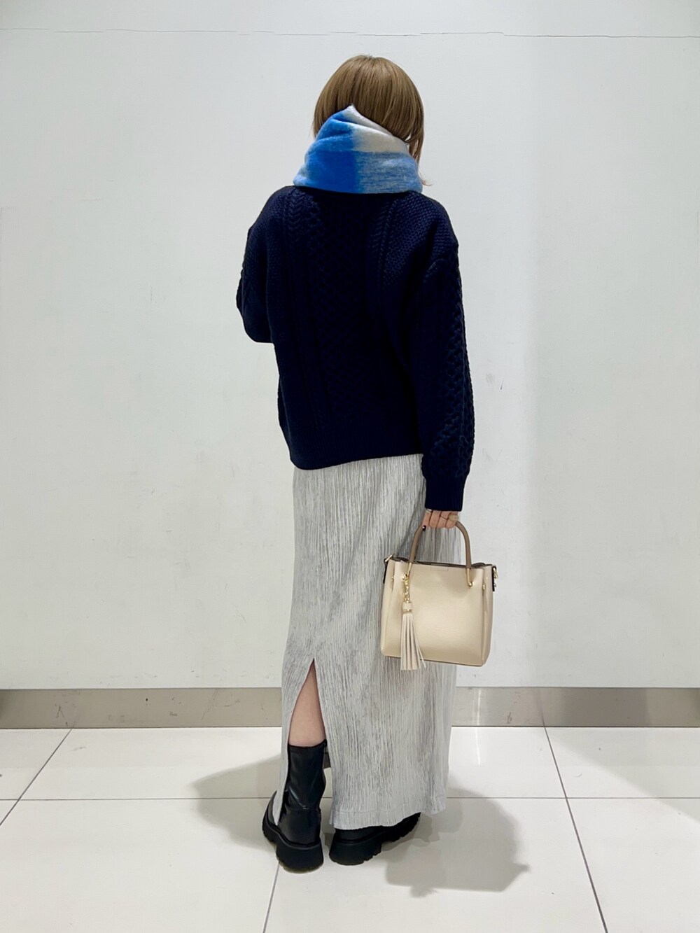 ブラック系のブーツ、グレー系のスカート、ブルー系のニット/セーターを着用したレディースの冬コーディネートの4枚目の写真