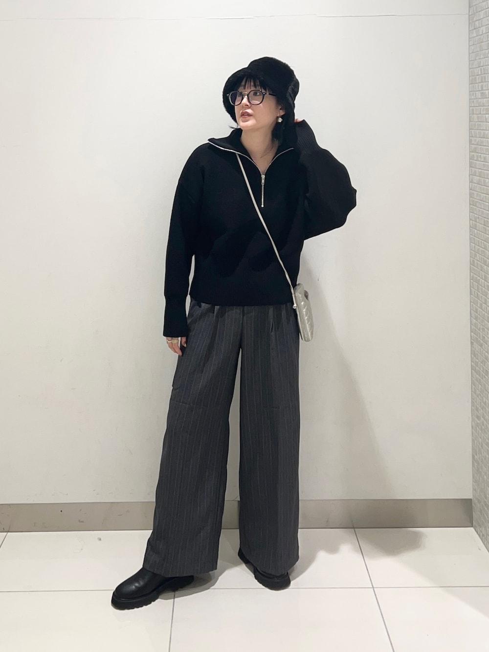 グレー系のその他パンツ、ブラック系のニット/セーター、シルバー系のショルダーバッグを着用したレディースの秋コーディネートの6枚目の写真