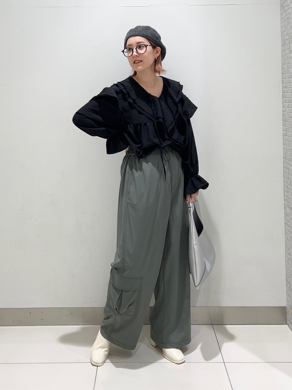 ブラック系のシャツ/ブラウス、グリーン系のサロペット/オーバーオール、ホワイト系のブーツを着用したレディースの秋コーディネートの2枚目の写真