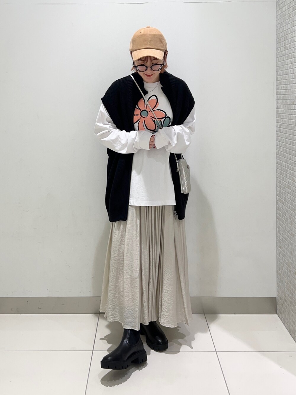 ホワイト系のTシャツ/カットソー、シルバー系のショルダーバッグ、ベージュ系のスカートを着用したレディースの秋コーディネートの6枚目の写真