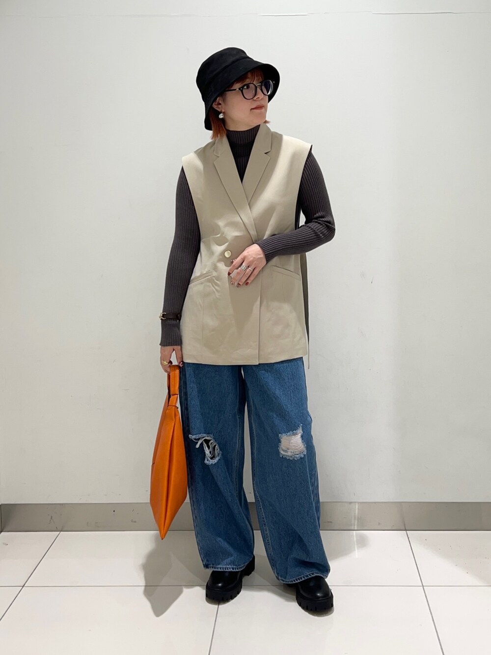ベージュ系のジャケット/アウター、グレー系のニット/セーター、ブラック系のブーツを着用したレディースの秋コーディネートの6枚目の写真