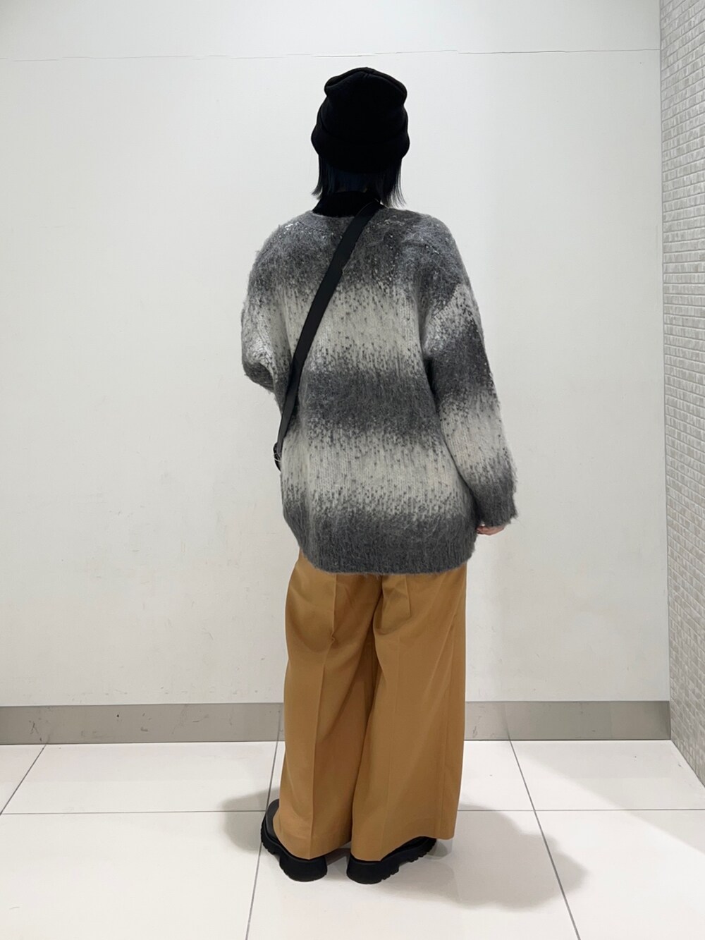 ブラック系のニット/セーター、ブラック系のショルダーバッグ、グレー系のカーディガン/ボレロを着用したレディースの秋コーディネートの4枚目の写真