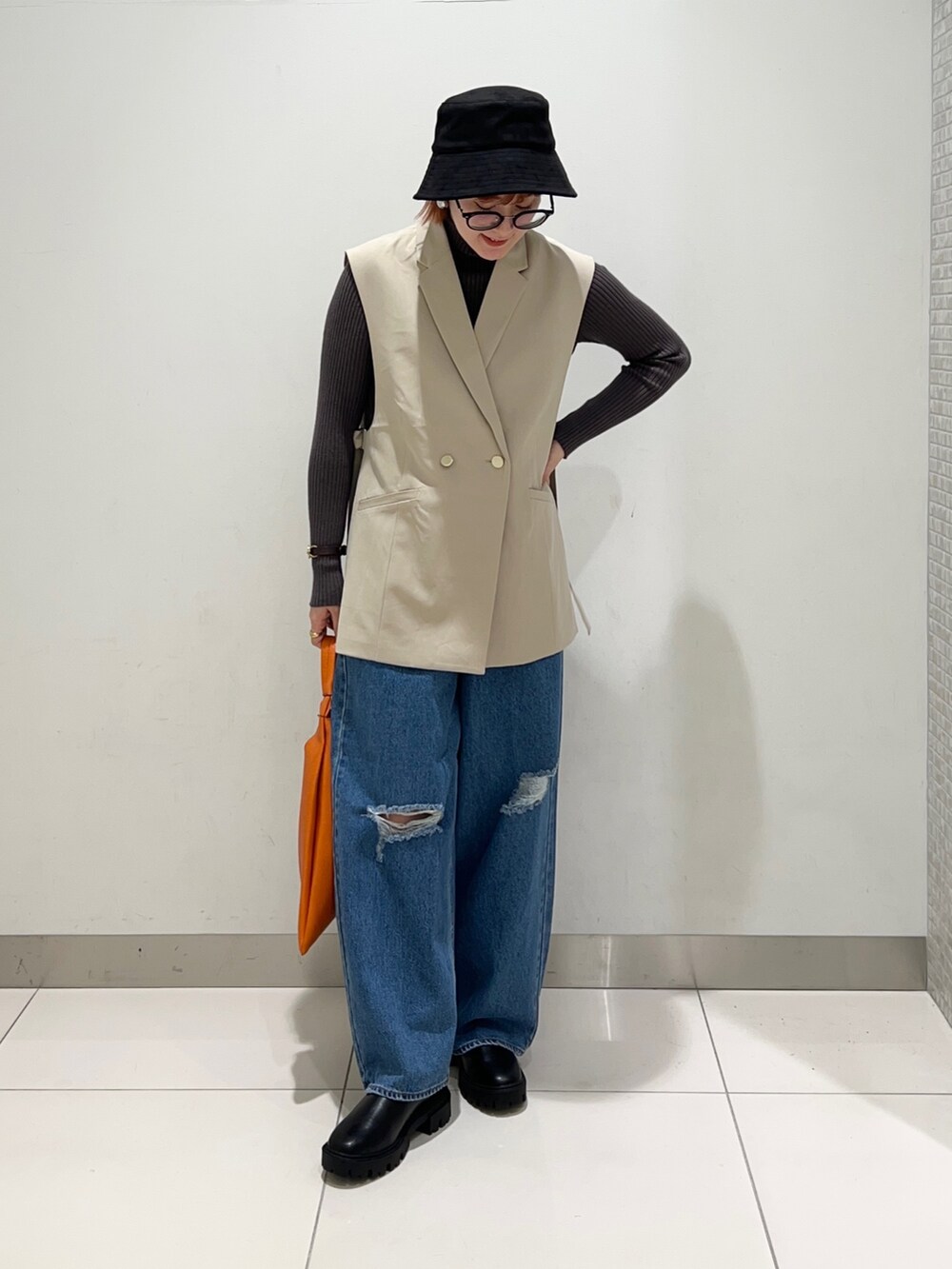 ベージュ系のジャケット/アウター、グレー系のニット/セーター、ブラック系のブーツを着用したレディースの秋コーディネートの2枚目の写真