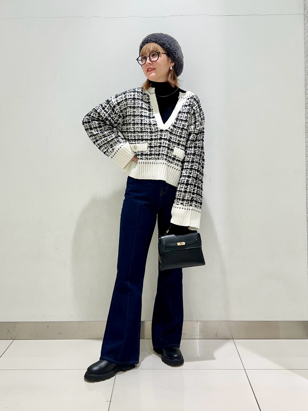 ベージュ系のステンカラーコート、ブルー系のデニムパンツ、ブラック系のショルダーバッグを着用したレディースの冬コーディネートの8枚目の写真