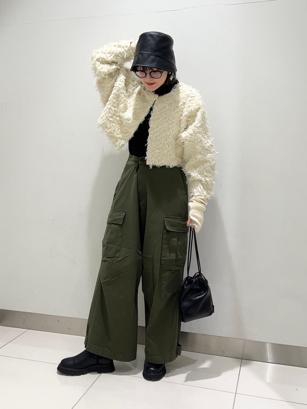 グリーン系のその他パンツ、ブラック系のショルダーバッグ、ブラック系のブーツを着用したレディースの秋コーディネートの2枚目の写真