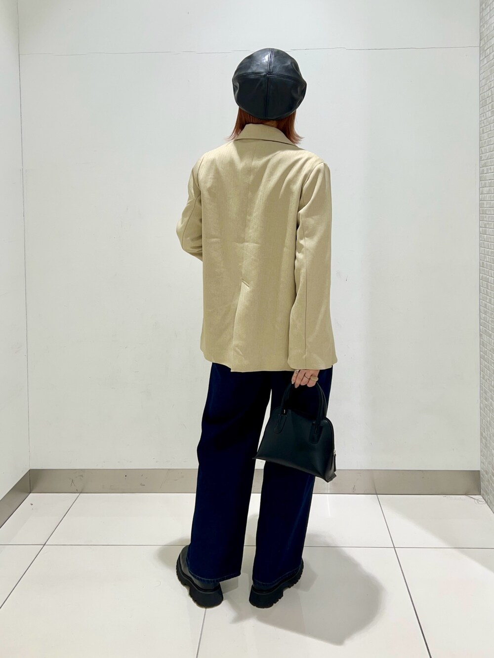 ブラック系のブーツ、ブルー系のデニムパンツ、ブラック系のショルダーバッグを着用したレディースの冬コーディネートの4枚目の写真