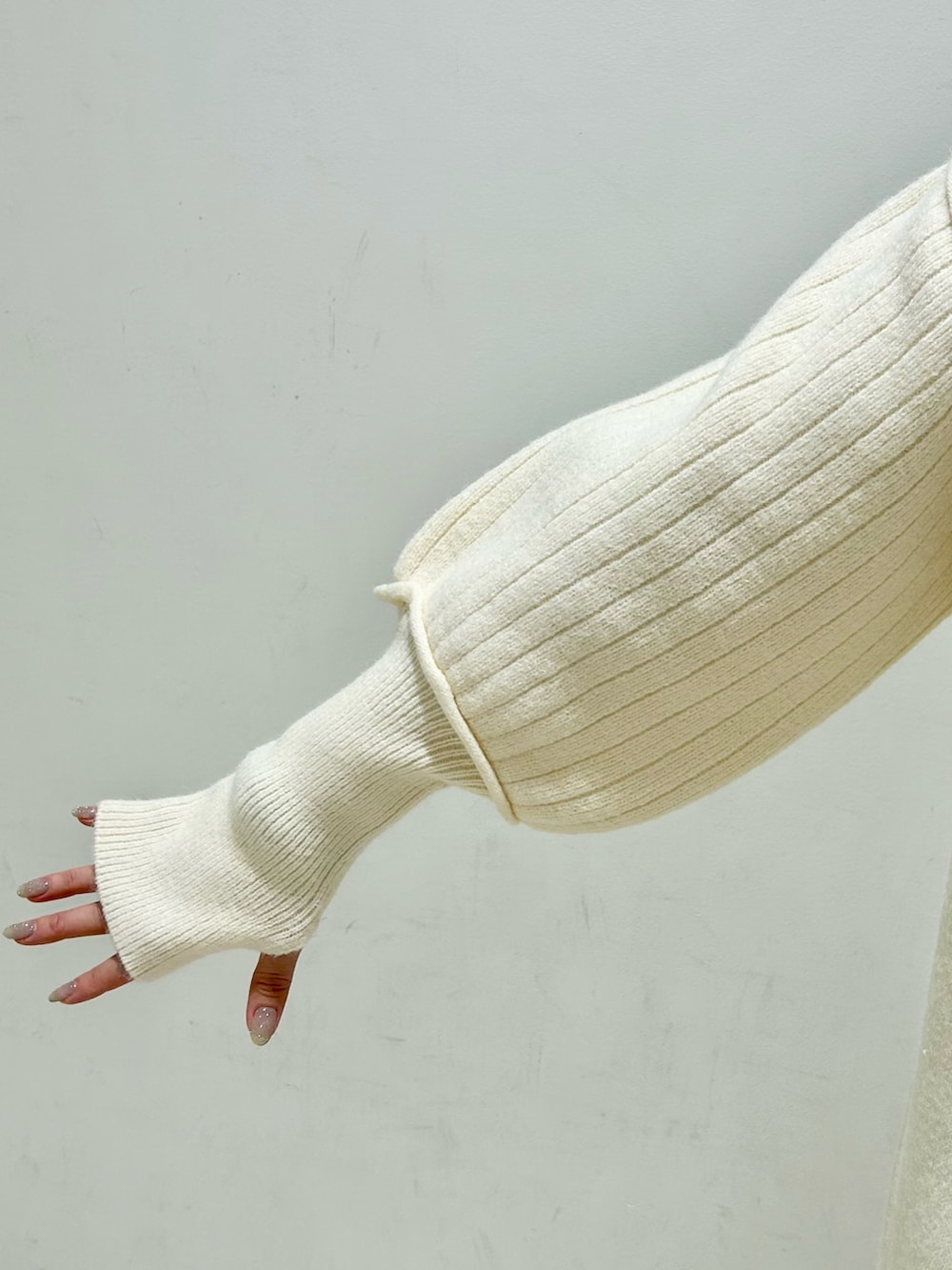 シルバー系のショルダーバッグ、ホワイト系のワンピース、ブルー系のデニムパンツを着用したレディースの冬コーディネートの10枚目の写真