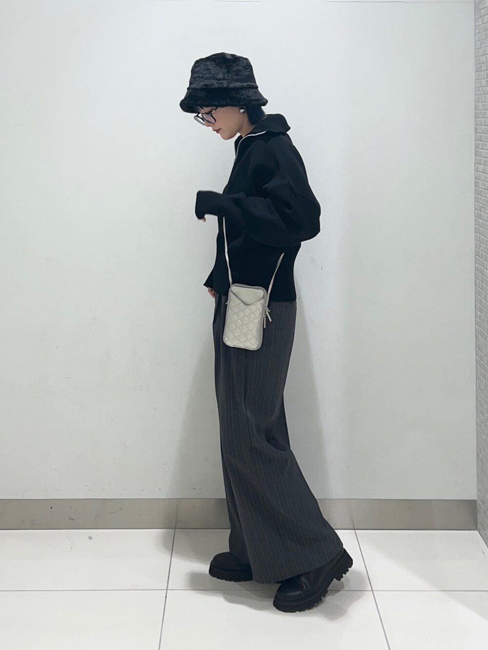 グレー系のその他パンツ、ブラック系のニット/セーター、シルバー系のショルダーバッグを着用したレディースの秋コーディネートの3枚目の写真