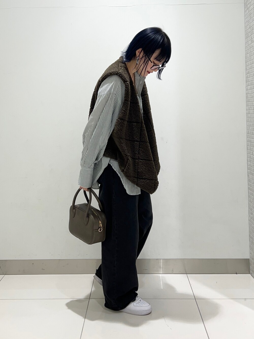 ブラック系のデニムパンツ、ブラウン系のボストンバッグ、グリーン系のシャツ/ブラウスを着用したレディースの秋コーディネートの5枚目の写真
