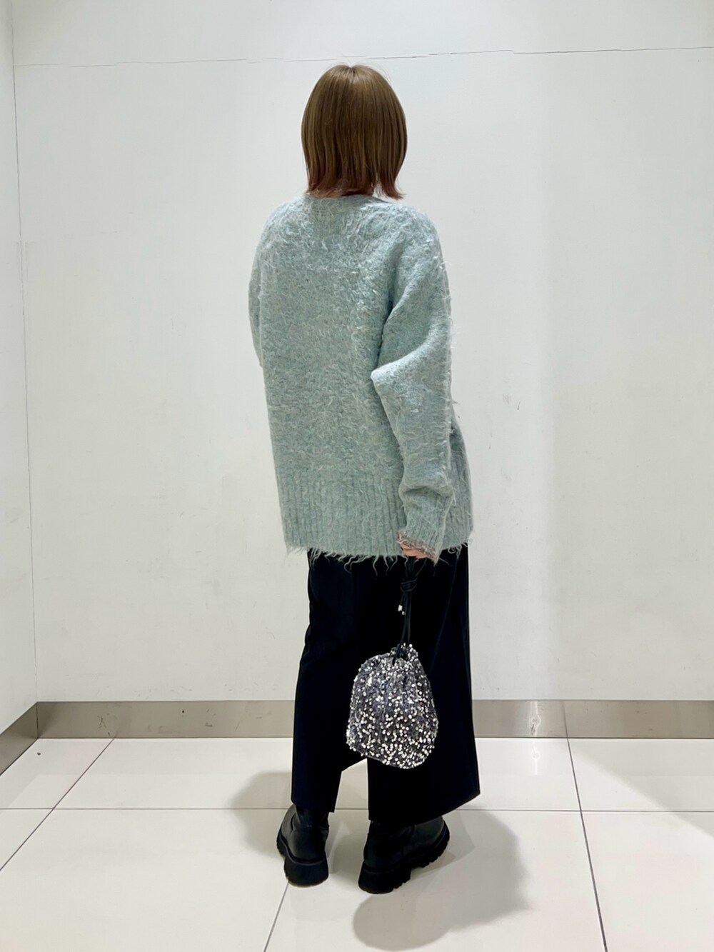 ブルー系のカーディガン/ボレロ、ブラック系のワンピース、ブラック系のブーツを着用したレディースの秋コーディネートの4枚目の写真