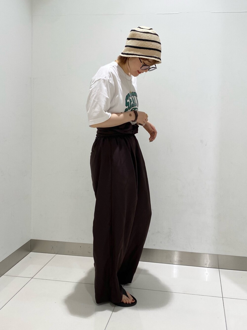 ホワイト系のTシャツ/カットソー、ブラウン系のサロペット/オーバーオール、ベージュ系のハットを着用したレディースの秋コーディネートの5枚目の写真