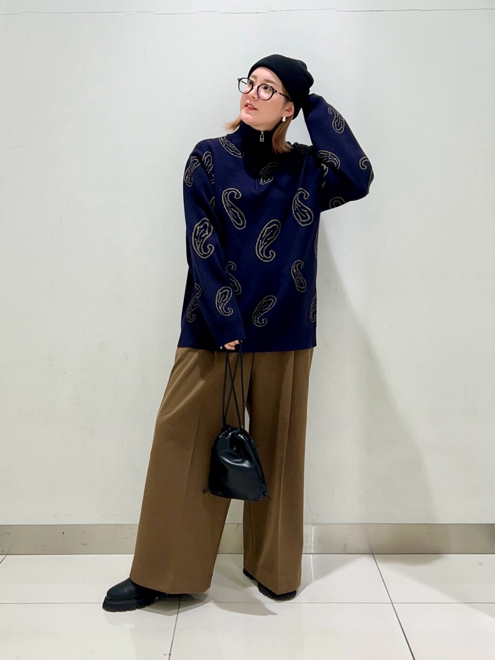 ブルー系のニット/セーター、ブラック系のショルダーバッグ、ベージュ系のその他パンツを着用したレディースの冬コーディネートの6枚目の写真