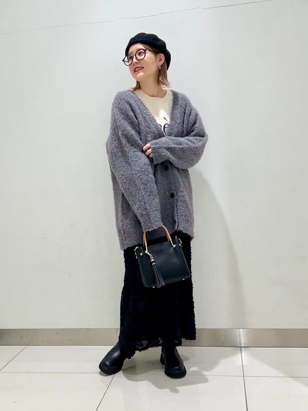 ホワイト系のニット/セーター、ブルー系のカーディガン/ボレロ、ブラック系のトートバッグを着用したレディースの冬コーディネートの6枚目の写真