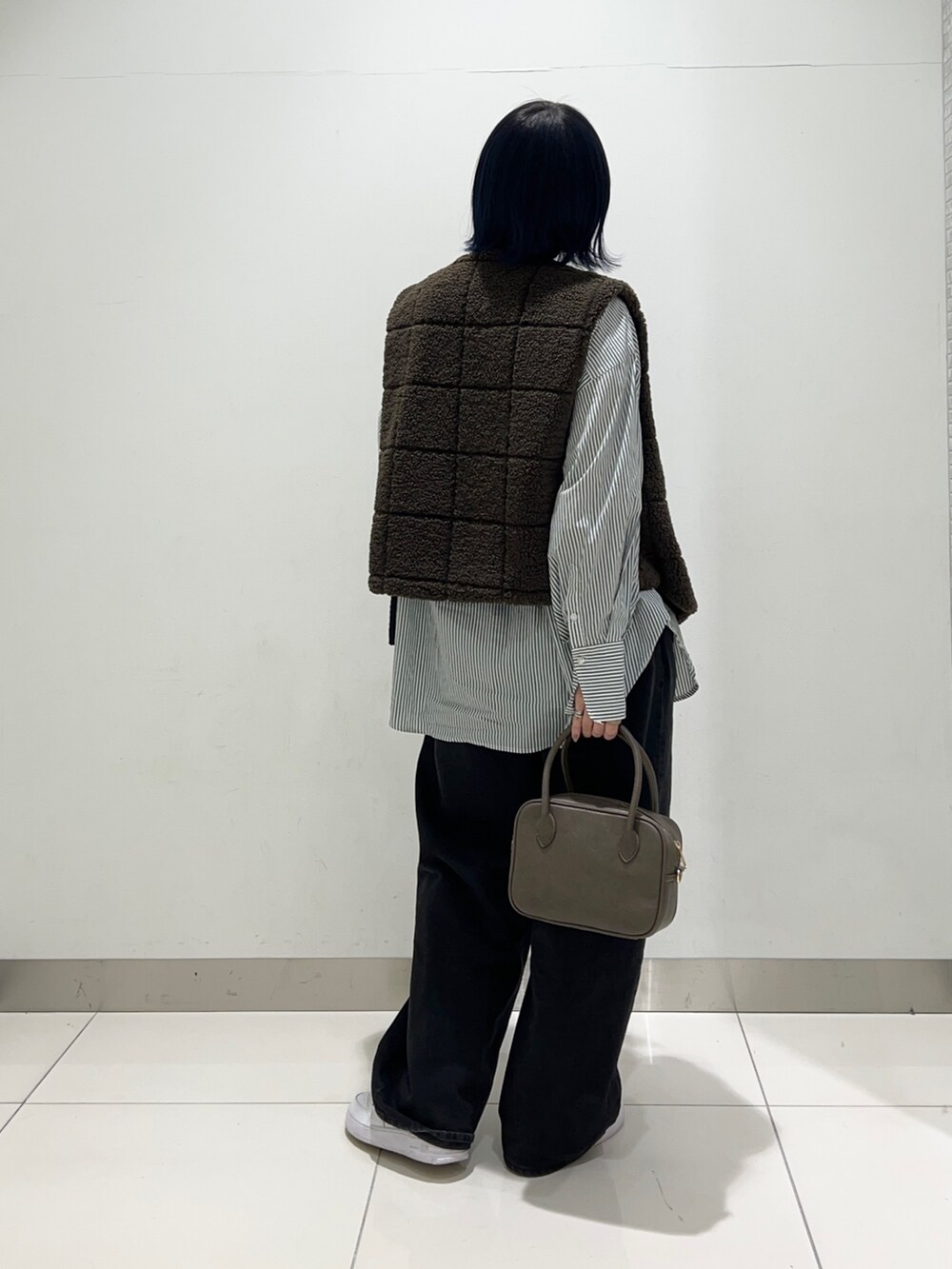 ブラック系のデニムパンツ、ブラウン系のボストンバッグ、グリーン系のシャツ/ブラウスを着用したレディースの秋コーディネートの4枚目の写真