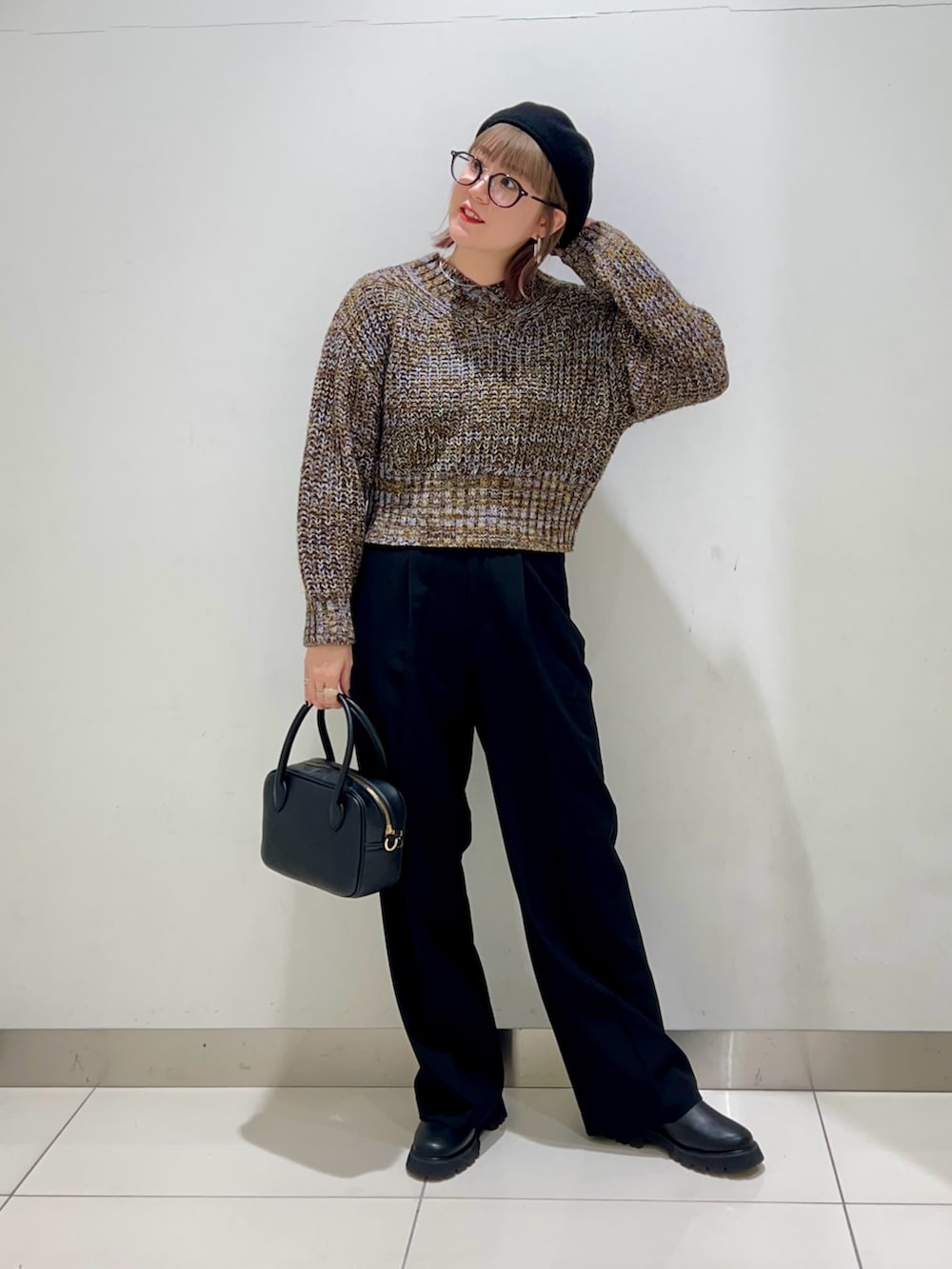 ブラック系のボストンバッグ、ブラック系のスラックス、ブラック系のブーツを着用したレディースの秋コーディネートの6枚目の写真