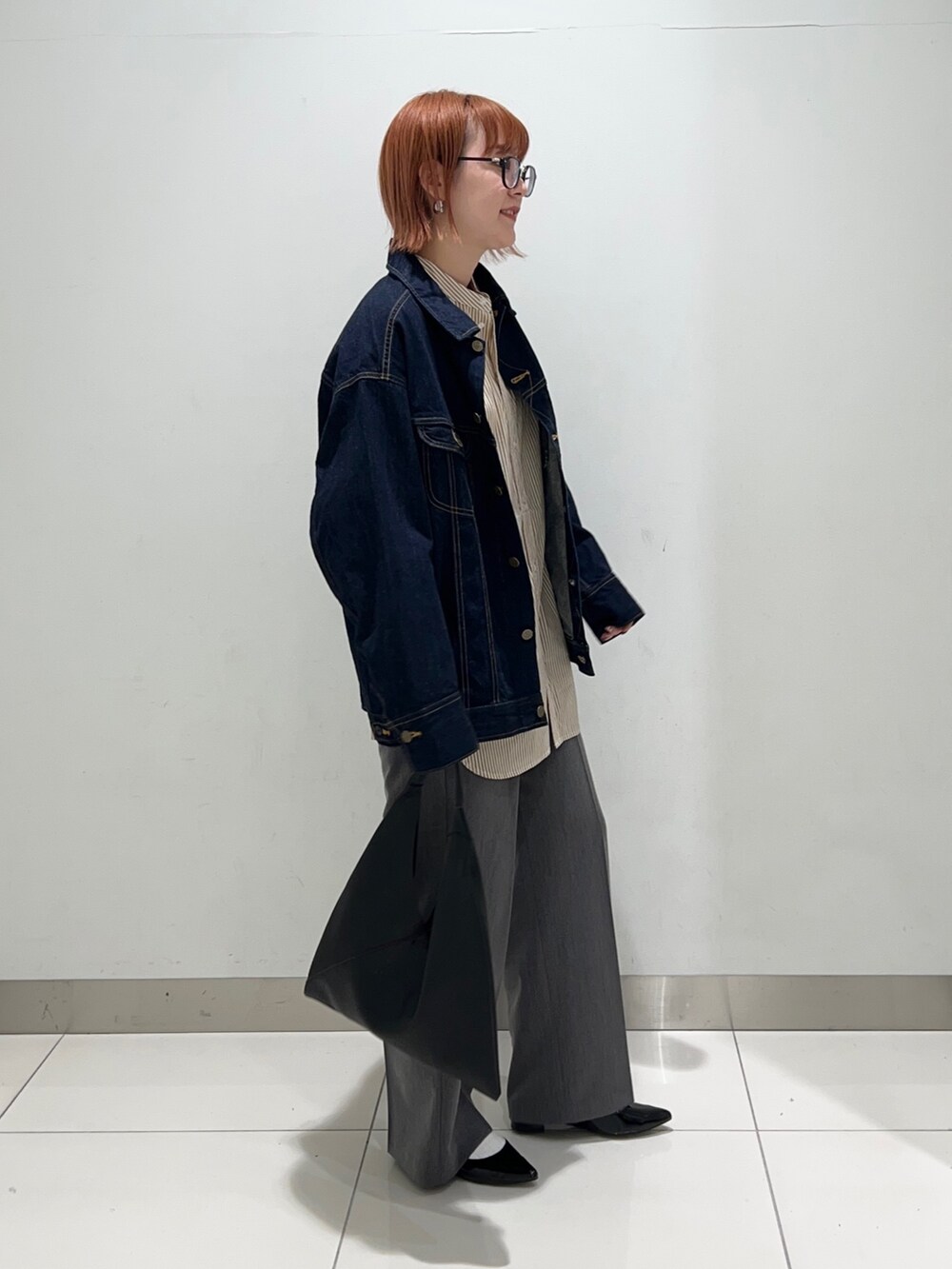 イエロー系のシャツ/ブラウス、ブルー系のデニムジャケット、グレー系のスラックスを着用したレディースの秋コーディネートの5枚目の写真