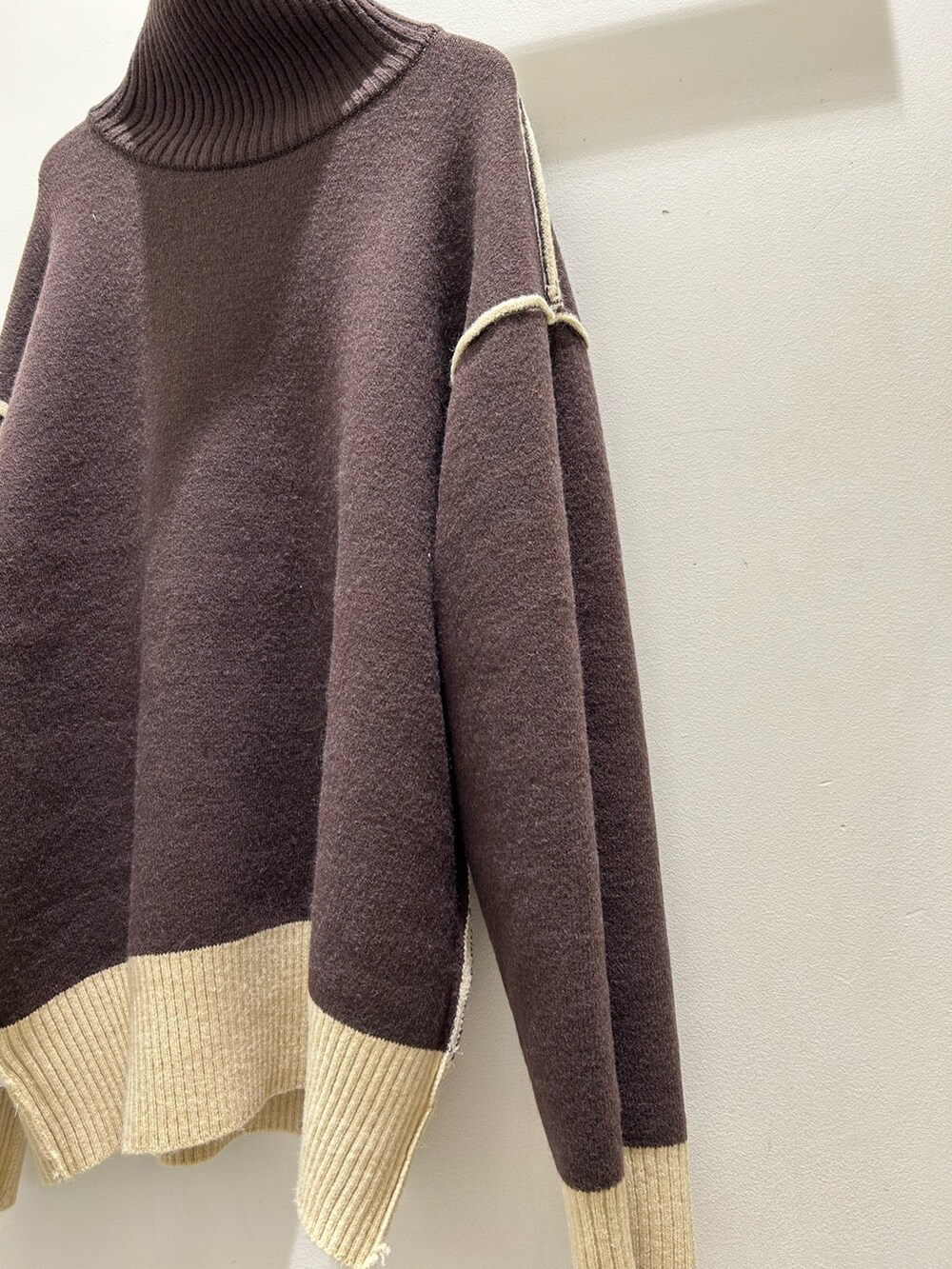 ブラック系のショルダーバッグ、ブルー系のデニムパンツ、ブラック系のブーツを着用したレディースの冬コーディネートの8枚目の写真