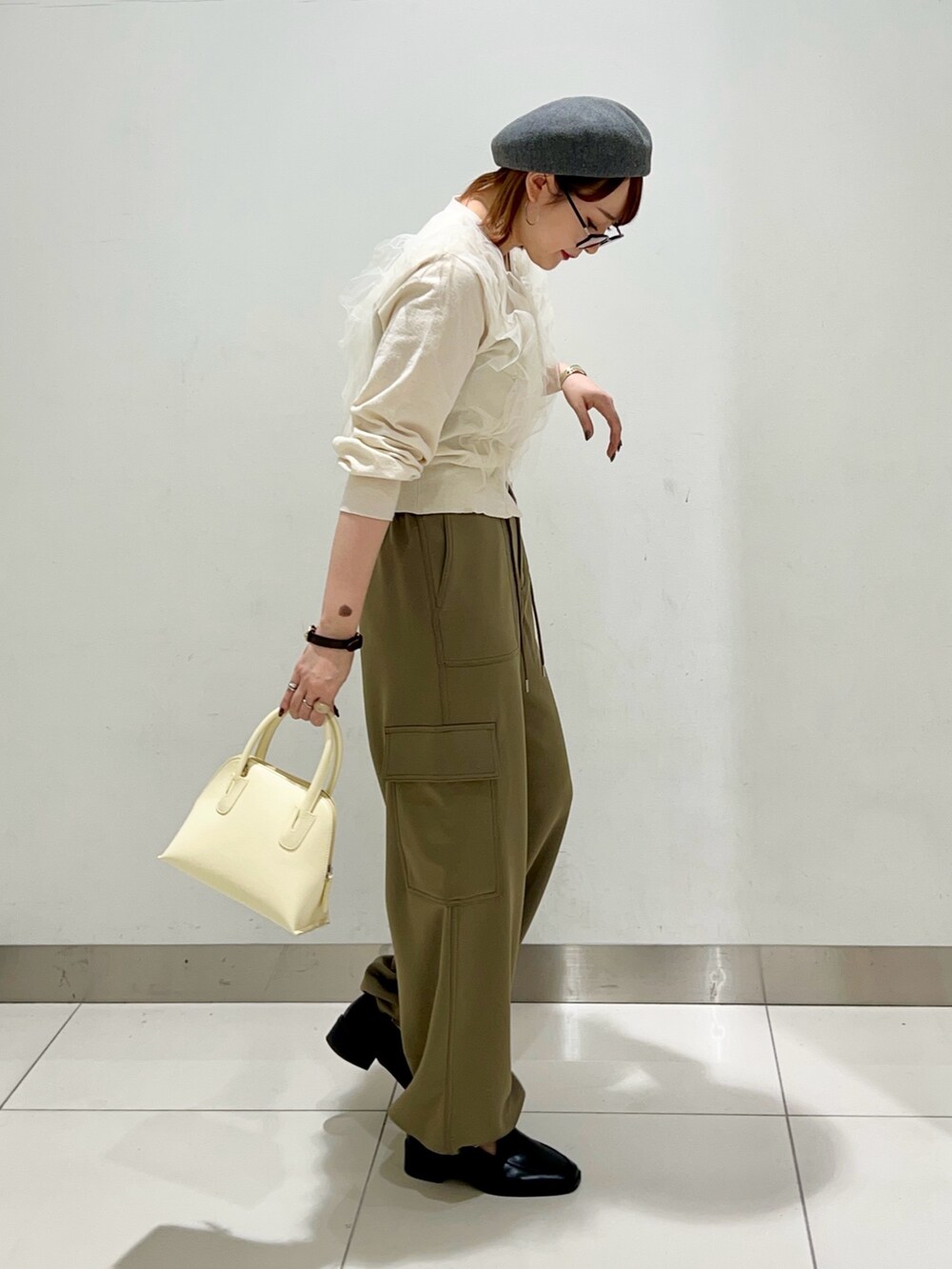 グリーン系のその他パンツ、イエロー系のショルダーバッグ、ブラック系のローファーを着用したレディースの冬コーディネートの5枚目の写真