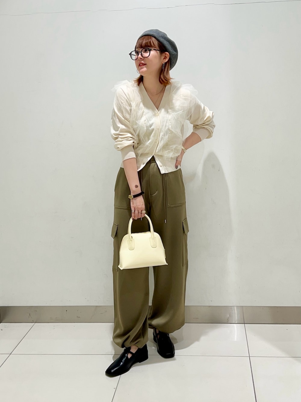 グリーン系のその他パンツ、イエロー系のショルダーバッグ、ブラック系のローファーを着用したレディースの冬コーディネートの6枚目の写真