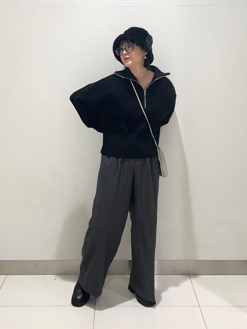 グレー系のその他パンツ、ブラック系のニット/セーター、シルバー系のショルダーバッグを着用したレディースの秋コーディネートの7枚目の写真