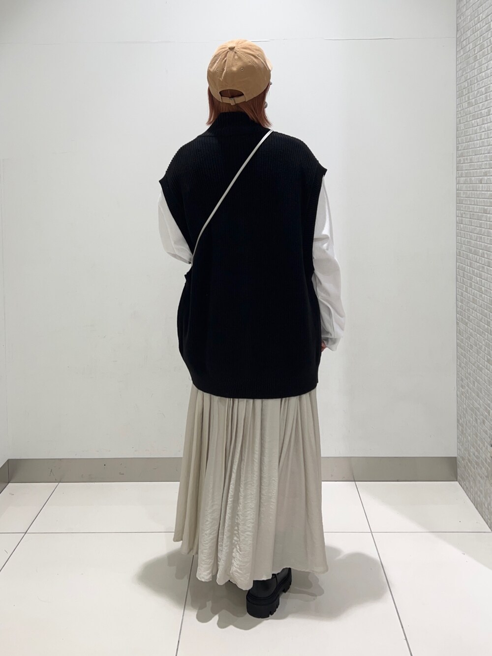 ホワイト系のTシャツ/カットソー、シルバー系のショルダーバッグ、ベージュ系のスカートを着用したレディースの秋コーディネートの4枚目の写真