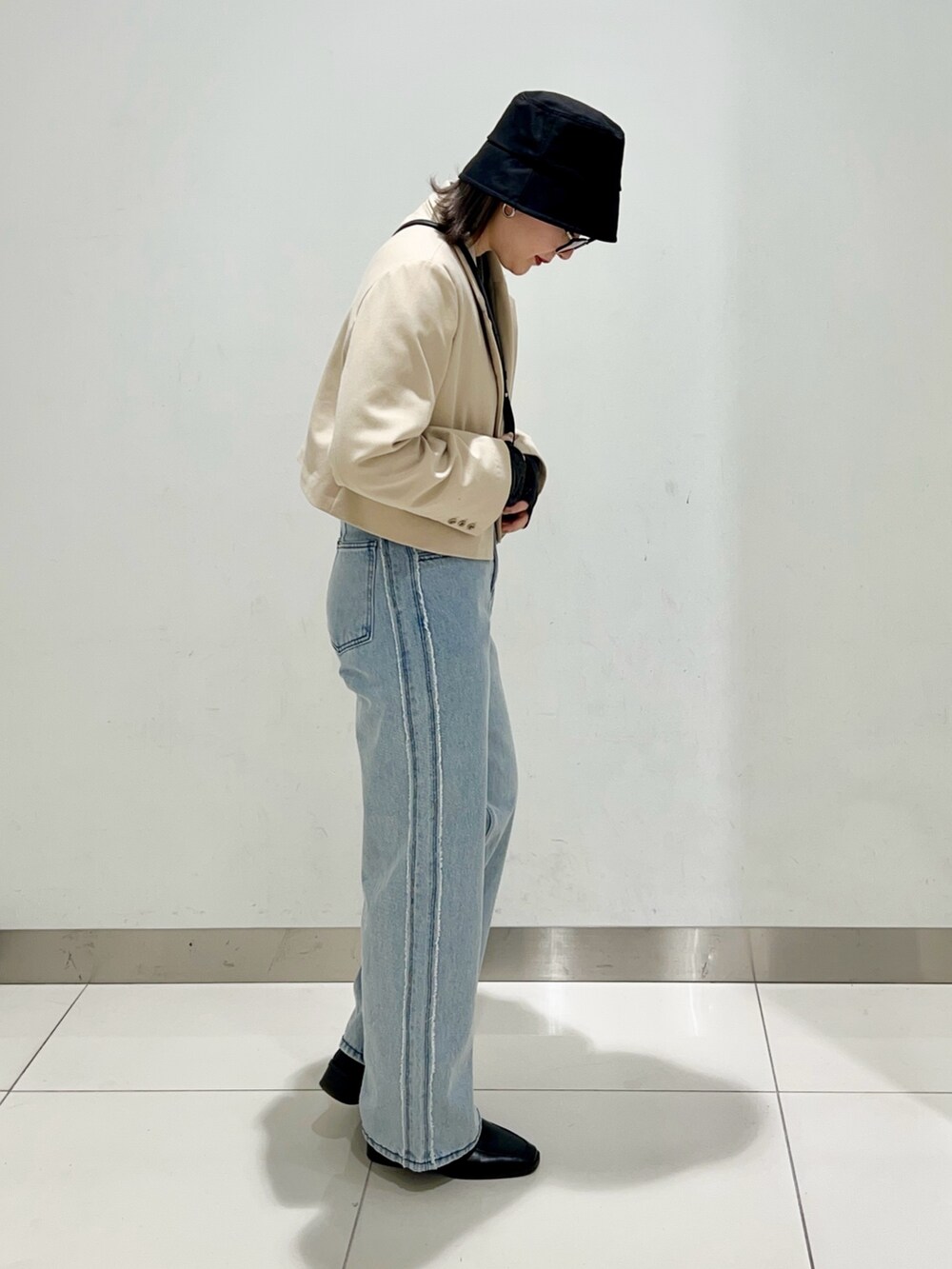 ブラック系のTシャツ/カットソー、ベージュ系のその他アウター、ブラック系のショルダーバッグを着用したレディースの春コーディネートの5枚目の写真