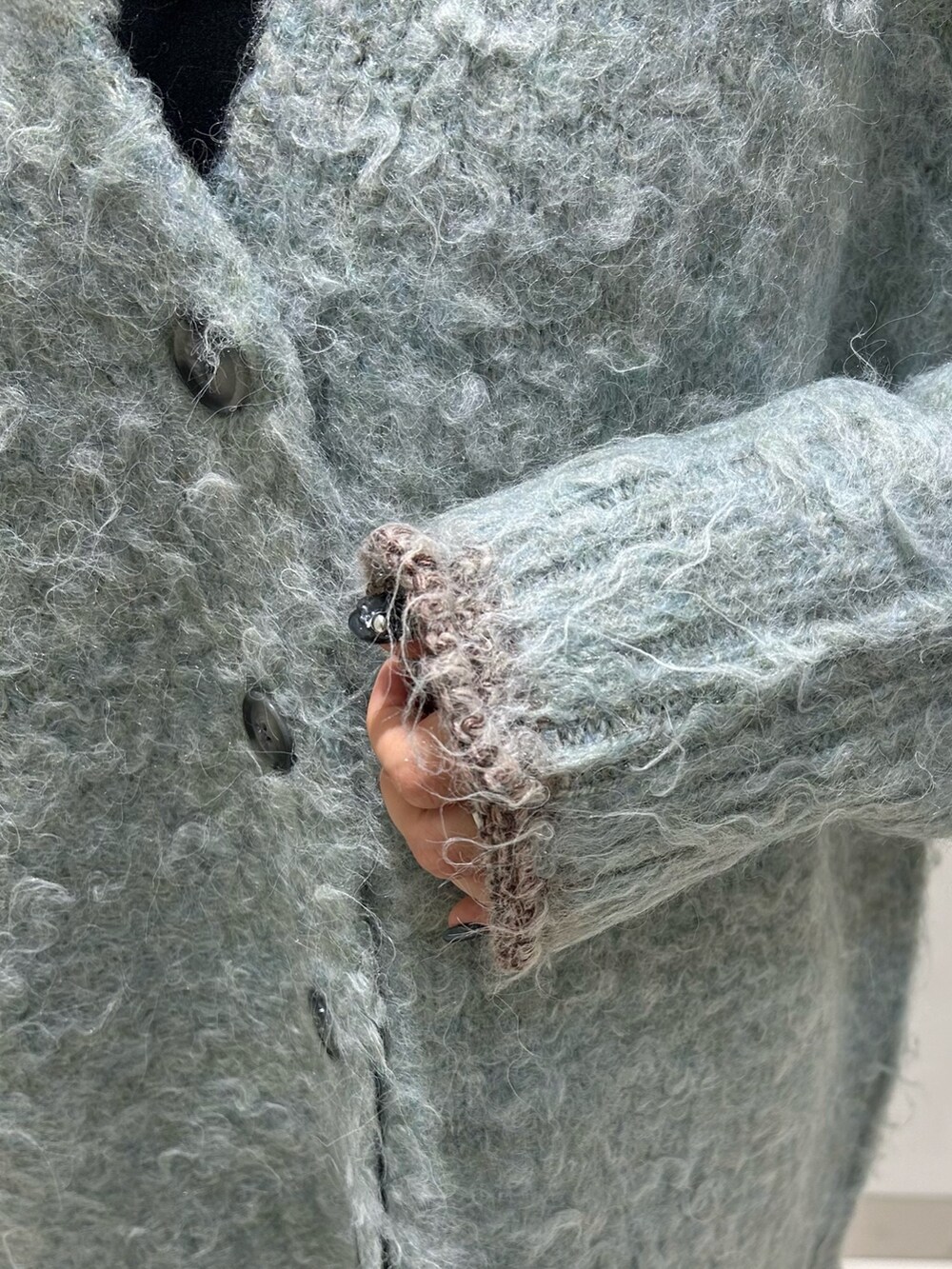 ブルー系のカーディガン/ボレロ、ブラック系のワンピース、ブラック系のブーツを着用したレディースの秋コーディネートの7枚目の写真