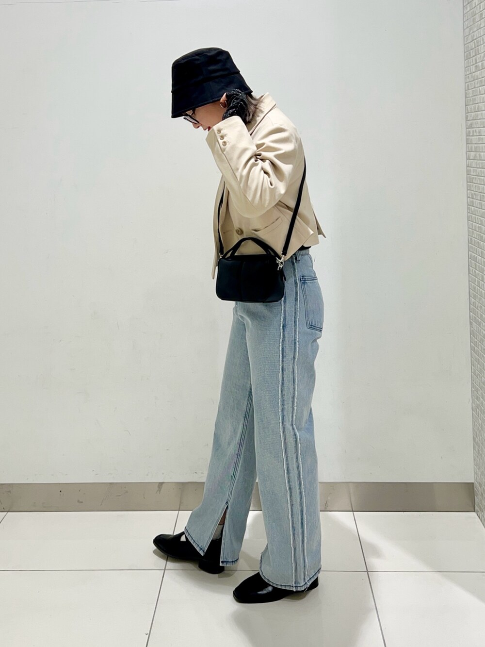 ブラック系のTシャツ/カットソー、ベージュ系のその他アウター、ブラック系のショルダーバッグを着用したレディースの春コーディネートの3枚目の写真