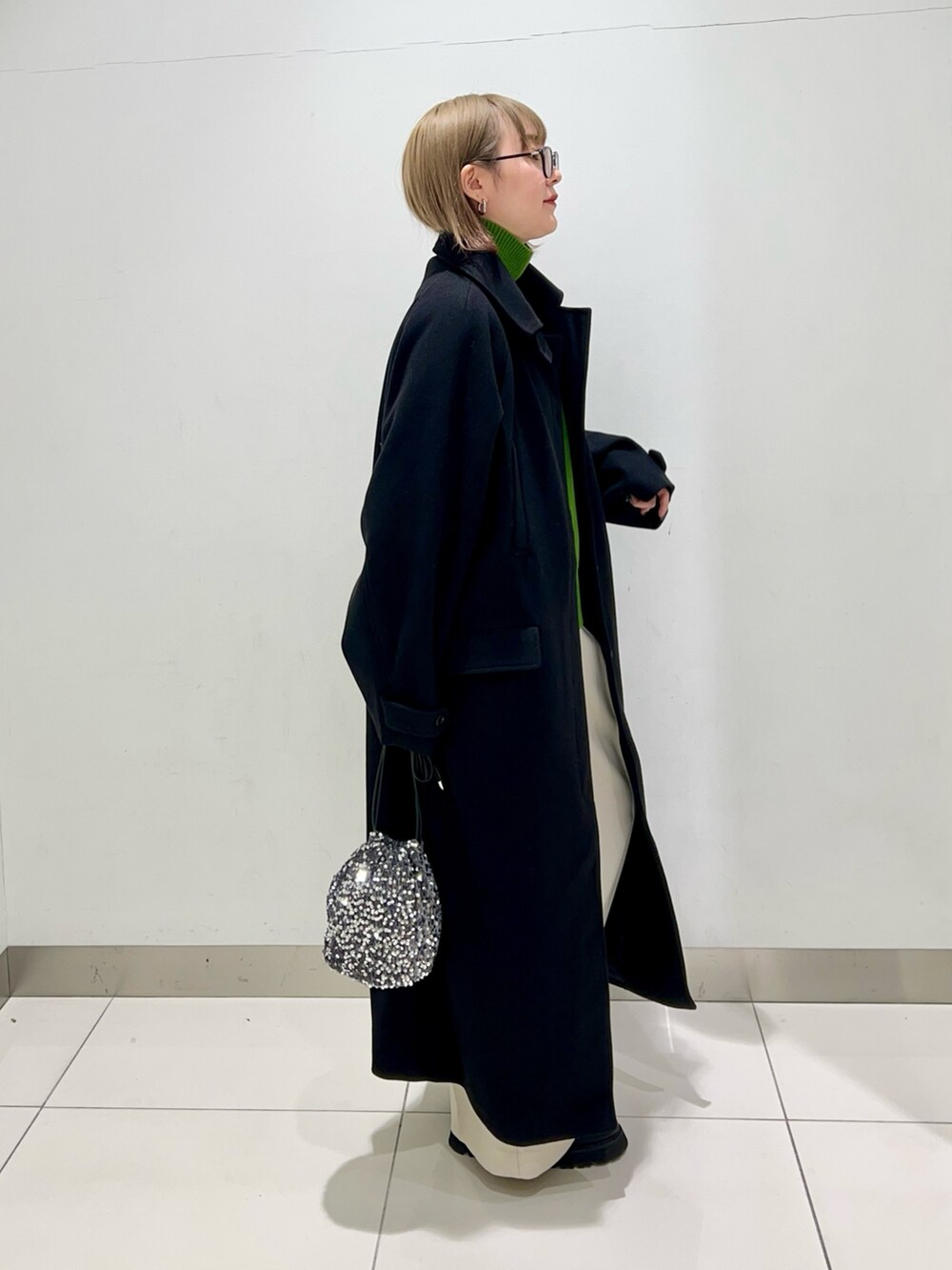 グリーン系のニット/セーター、ホワイト系のその他パンツ、ブラック系のブーツを着用したレディースの冬コーディネートの7枚目の写真