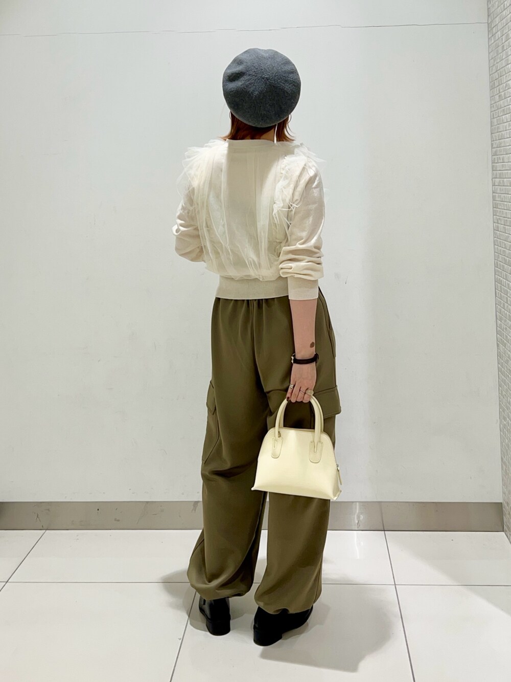 グリーン系のその他パンツ、イエロー系のショルダーバッグ、ブラック系のローファーを着用したレディースの冬コーディネートの4枚目の写真